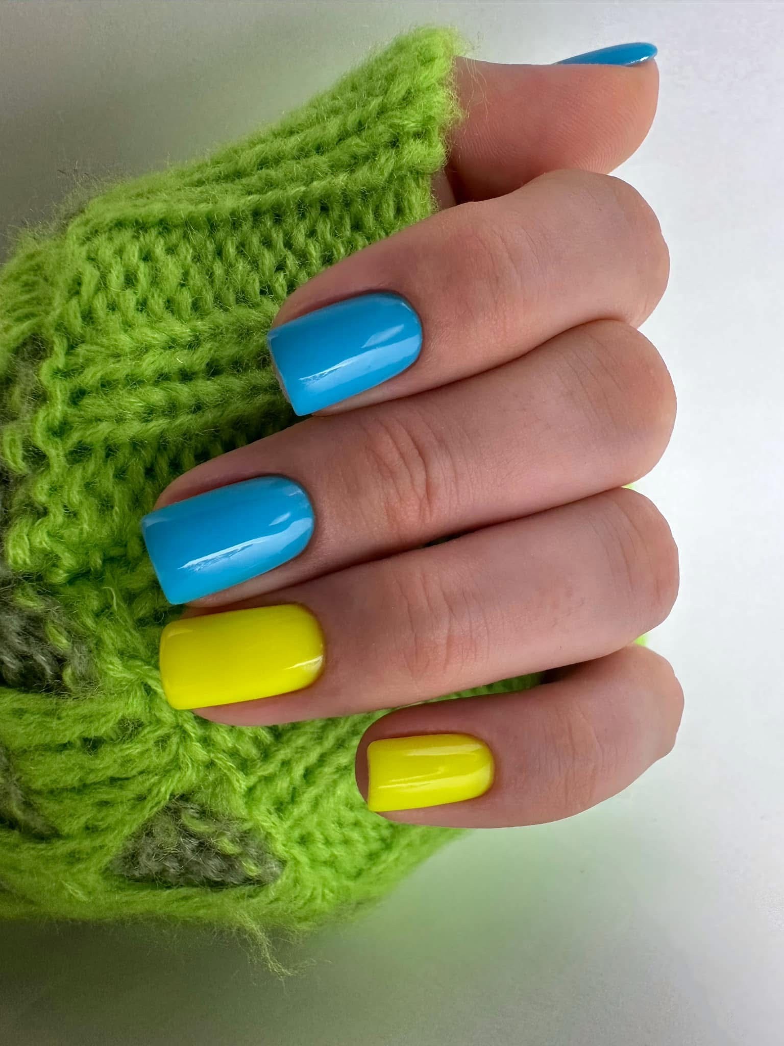Frische korallenrote Gelnägel auf kurzen eckigen Nägeln für einen sommerlichen Look.