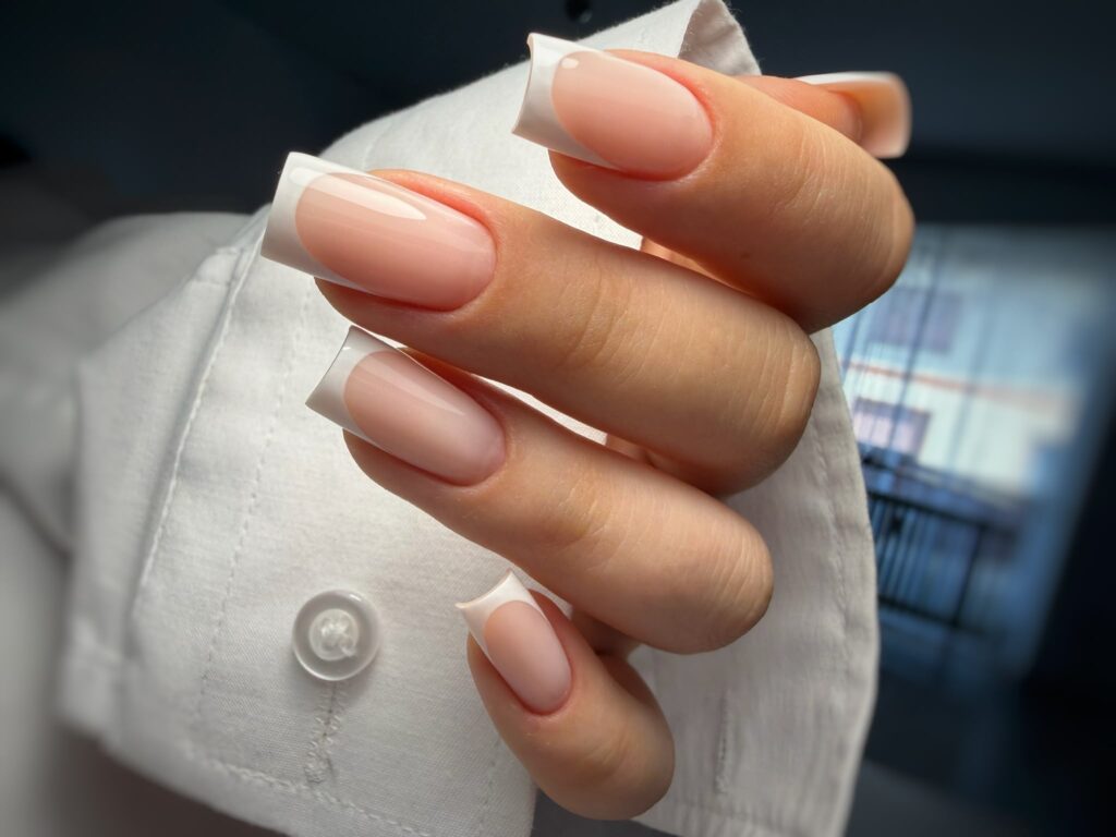Elegante weiße Gelnägel mit edlem Marmor-Effekt und feinen Akzenten aus Blattgold.