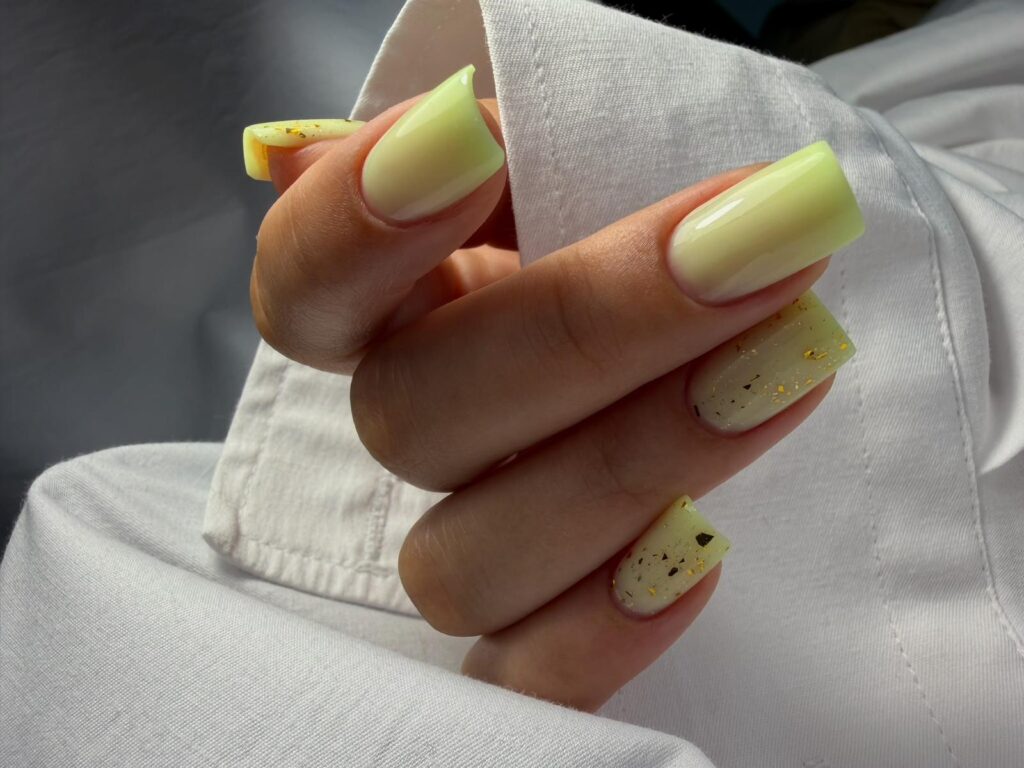 Modernes Nageldesign mit handgemalten geometrischen Linien auf pastellfarbenen Gelnägeln.