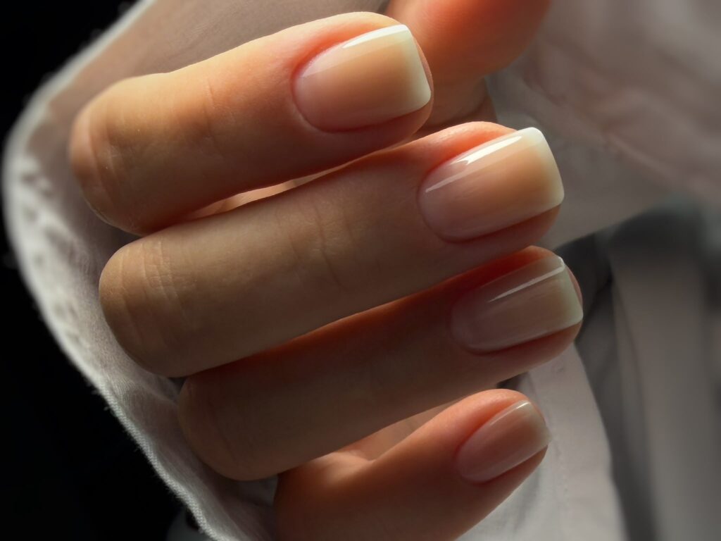Elegante Brautnägel in Soft Weiß mit dezentem Glitzer und feinen Steinchen für die Hochzeit.